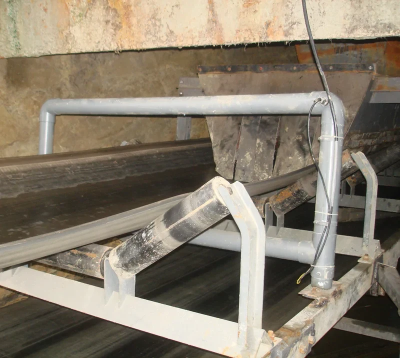 Frame-style conveyor metal detector installed around a bulk-material belt conveyor