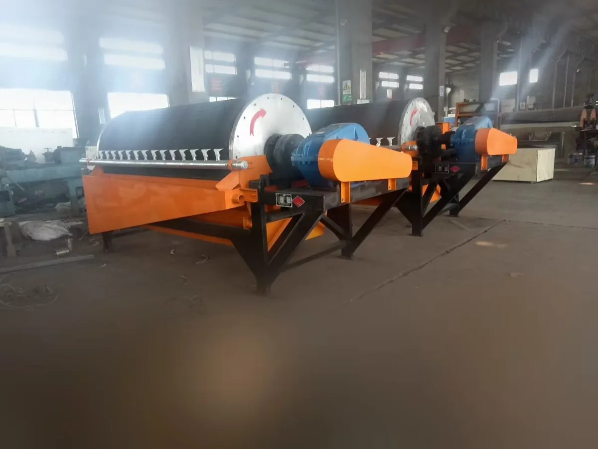 Two wet drum magnetic separator units with drum, tank and drive assemblies in a workshop.