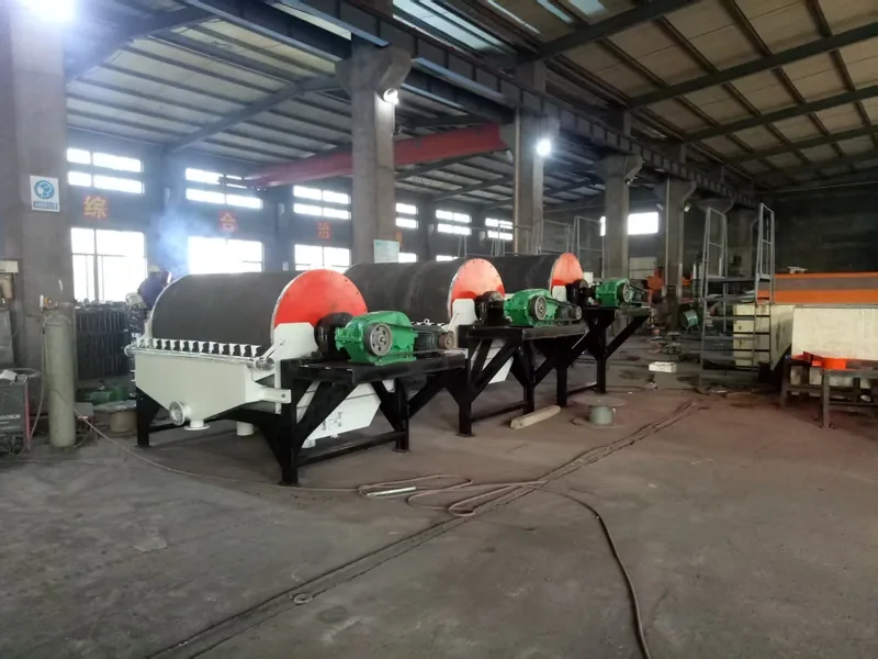 Multiple wet drum magnetic separator units arranged in a workshop.